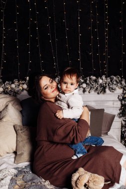 Mutlu anne ve oğul yatakta poz veriyor. 