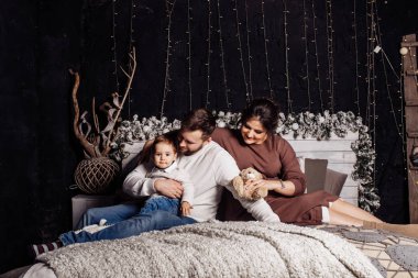 Mutlu genç aile yatağa poz