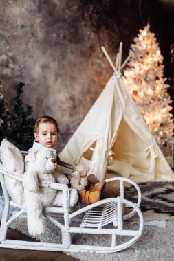 Sandalyede oturan mutlu sevimli çocuk 