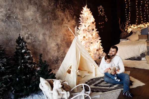 Happy young father   with son sitting near tent