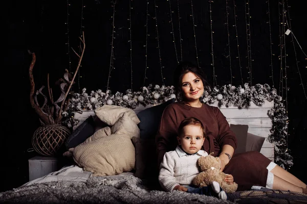 Mutlu anne ve oğul yatakta poz veriyor. 