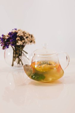 beyaz arka planda demlik ve çiçek meyve çayı