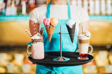 tatlılar ile tepsi tutan garson