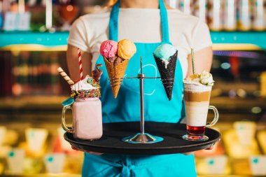 tatlılar ile tepsi tutan garson