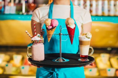 tatlılar ile tepsi tutan garson