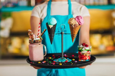 tatlılar ile tepsi tutan garson