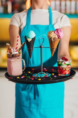 tatlılar ile tepsi tutan garson