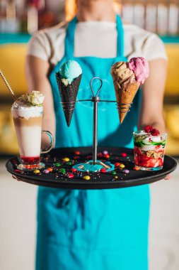 tatlılar ile tepsi tutan garson