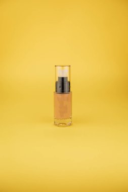 sarı arka plan üzerinde kozmetik serum ile şişe 
