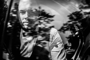 Genç yakışıklı mutlu adam arabada poz veriyor. 