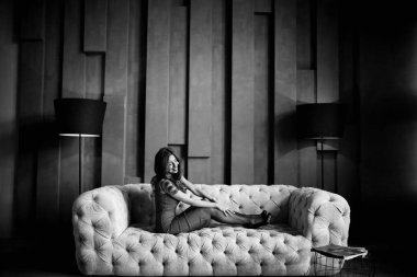 Kanepede poz veren güzel genç bir kadın. 