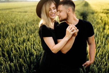 Güzel genç çift buğday tarlasında sarılma