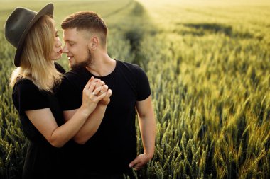 Güzel genç çift buğday tarlasında sarılma