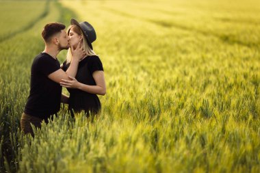 Güzel genç çift buğday tarlasında öpüşme