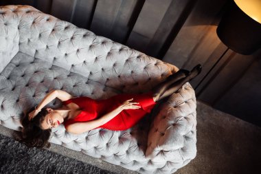 Kanepede poz veren güzel genç bir kadın. 