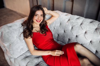 Kanepede poz veren güzel genç bir kadın. 