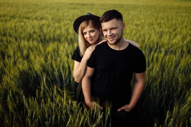 Güzel genç çift buğday tarlasında sarılma