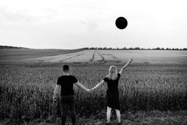 Buğday tarlasında şapka atan güzel genç çift