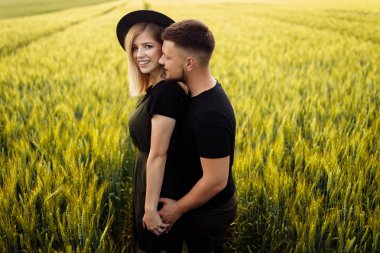 Güzel genç çift buğday tarlasında sarılma