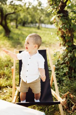 Parktaki sandalyede dinlenen mutlu çocuk.