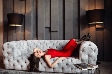 Kanepede poz veren güzel genç bir kadın. 