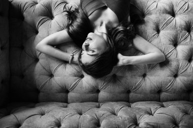 Kanepede poz veren güzel genç bir kadın. 