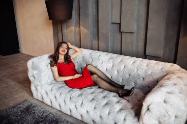 Kanepede poz veren güzel genç bir kadın. 