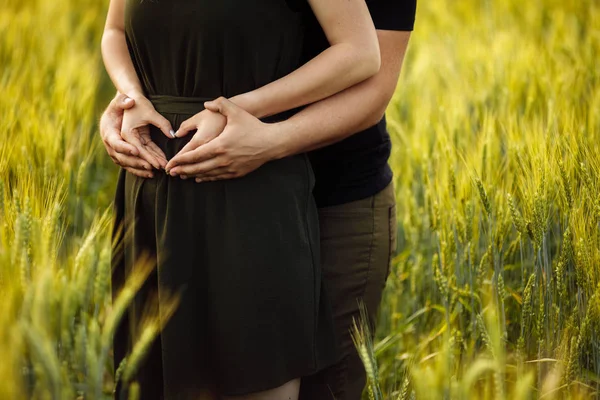 ハートサインを作る小麦畑の美しい若いカップル — ストック写真