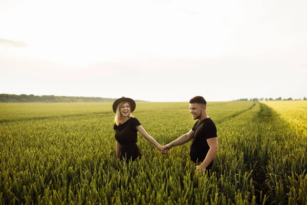 小麦畑を歩く美しい若いカップル — ストック写真