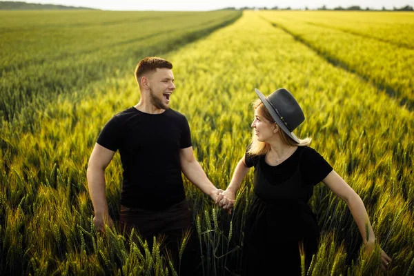 Güzel genç çift buğday tarlasında yürüyor