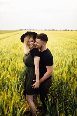 Güzel genç çift buğday tarlasında sarılma