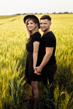 Buğday tarlasında güzel genç çift poz
