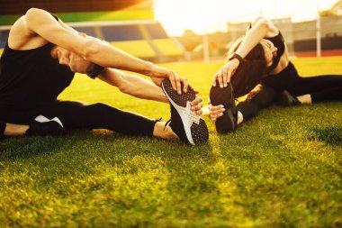 Genç sporcular parkta egzersiz yapıyor.