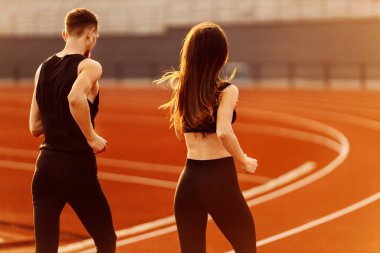 Stadyumda koşan iki genç sporcu