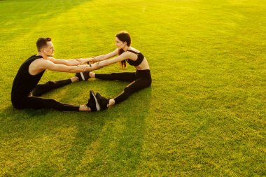 Genç sporcular parkta egzersiz yapıyor.