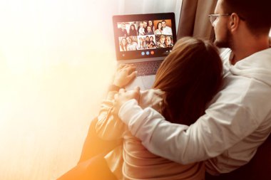 Genç çift evde arkadaşlarıyla internet üzerinden iletişim kuruyor.