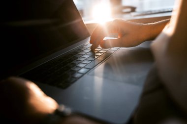 İşadamı ofiste dizüstü bilgisayar ve akıllı telefonla çalışıyor.