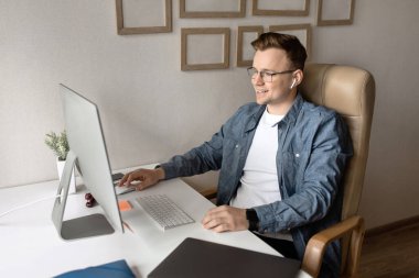 Genç işadamı masada oturuyor ve çalışıyor. 