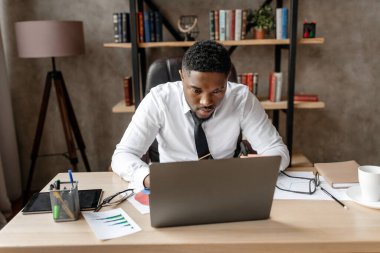 Genç işadamı dizüstü bilgisayarla çalışıyor 