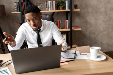 Genç işadamı dizüstü bilgisayarla çalışıyor 