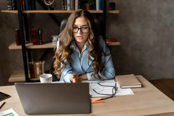 young woman working in office with laptop