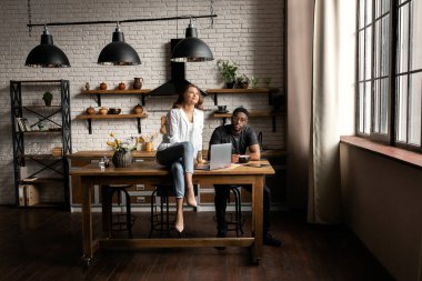 Mutfakta dizüstü bilgisayarla çalışan genç çift. 