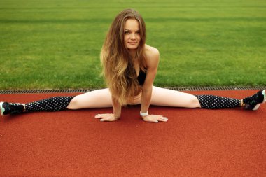 Stadyumda egzersiz yapan genç ve formda bir kadın. 