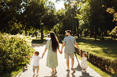 Parkta dinlenen çocuklu mutlu bir aile.