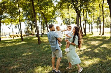 Parkta dinlenen çocuklu mutlu bir aile.