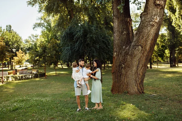 公園でリラックスしている子供たちと幸せな若い家族 — ストック写真