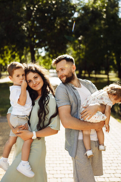 Happy young family with children relaxing  in the park