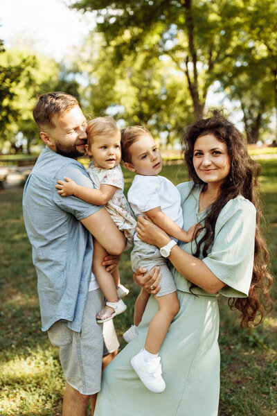 Happy young family with children relaxing  in the park