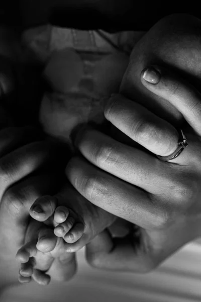 Portrait of beautiful little legs with tiny fingers, of adorable newborn baby girl, in caring mother arms, happy family moments, birth and childhood concept