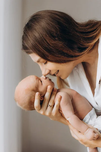 Mulher adorável segurar bebê recém-nascido menina nos braços, mãe carinhosa com a filha pequena toque suavemente com narizes, sorrindo, desfrutar de momentos parentais ternos, conceito de maternidade — Fotografia de Stock